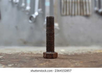 Old rusty bolt on workshop table.