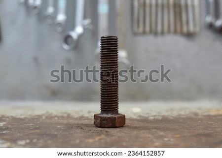 Old rusty bolt on workshop table.