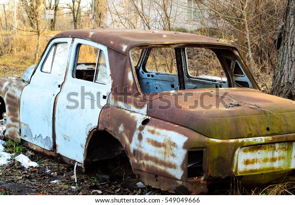 Old rusty car body on a\
ground