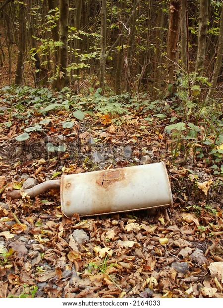 Old rusty car\
exhaust system in forest.\
Ecology
