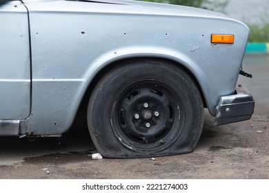 An Old Rusty Car With A Punctured Front Wheel.