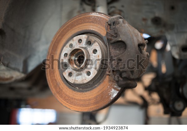 Old and rusty car's suspension parts. Rusted disc
brake and caliper on the car. Automotive industry and garage
concepts. Selective focus