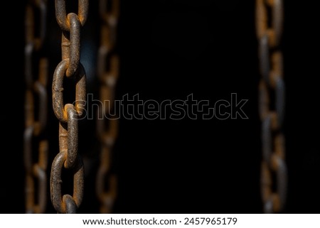 Old rusty chains on dark background with selective focus and copy space.