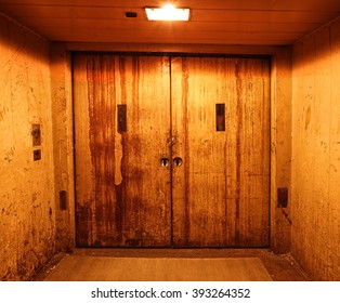 Old And Rusty Closed Elevator Doors In A Dark Hallway