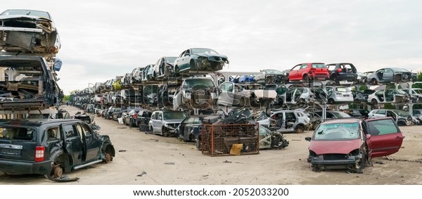 Old rusty\
corroded and crushed cars in car scrapyard. Car recycling. \
Ecological concept by dump of wrecked cars.\
