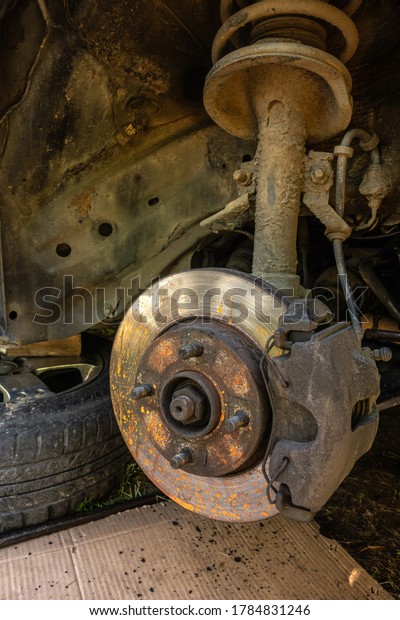 Old,\
rusty disc brakes and pads on the car in\
repair