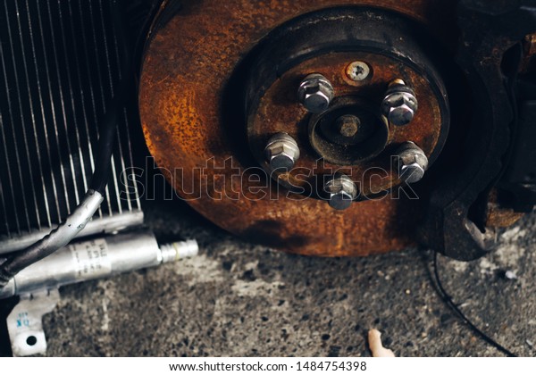 Old rusty disk\
brake of car in the garage.
