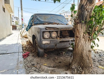 Old Rusty And Dusty Car Parked In The Street. 