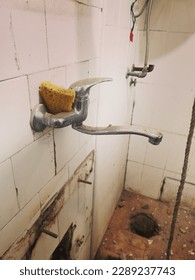 Old, rusty faucet in the kitchen, limestone, scum, need a replacement.
