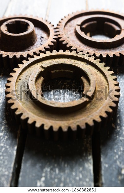 Old rusty\
gears from machines on a wooden\
table.