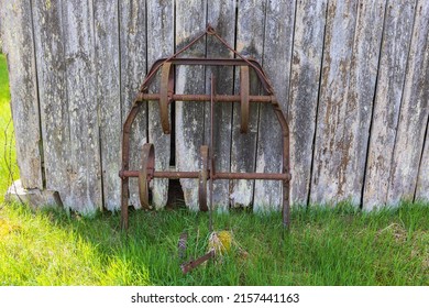 Old Rusty Harrow By A Wooden Wall