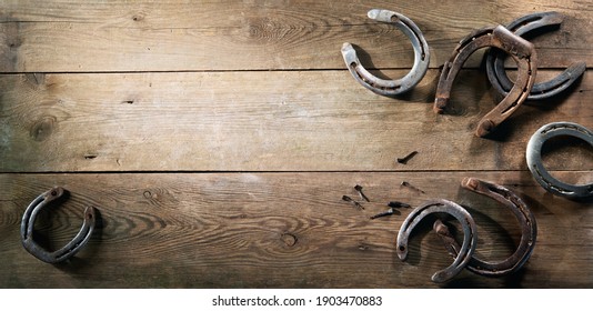 Old rusty horse shoes lying on a wooden barn floor - Powered by Shutterstock