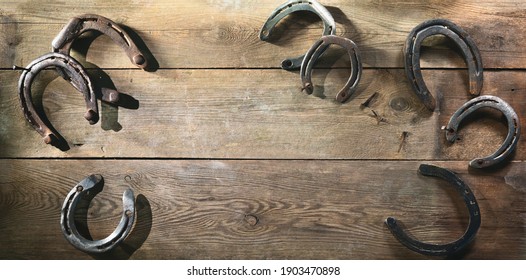 Old Rusty Horse Shoes Lying On A Wooden Barn Floor