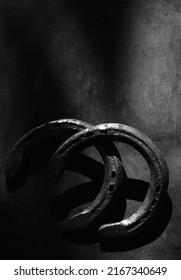 Old Rusty Horseshoes On Wood Background In Black And White For Western Rustic Equine Background.