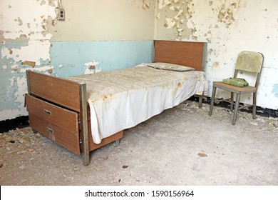 Old Rusty Hospital Bed Covered In Vines Inside Of Abandoned Mental Hospital Insane Asylum