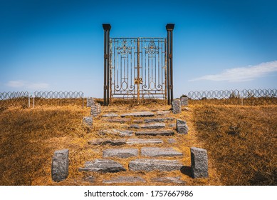 Old Rusty Iron Gate In The Middle Of A Field Leading To Nowhere. Concept Of Purgatory, Limits, Frontiers And Freedom