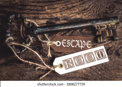an old rusty key on a ribbed wooden table and  labels with the text Escape room