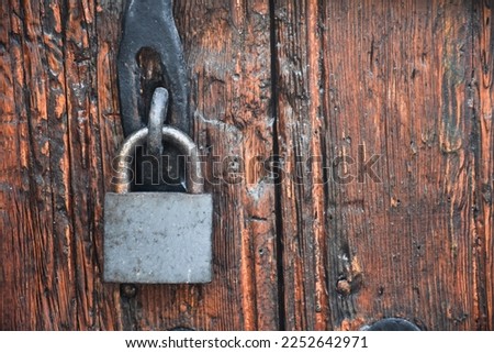 Old rusty lock hook and padlock on wooden door. Old rustic wooden door with padlock vintage concept