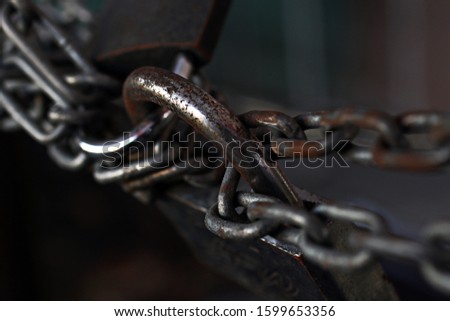 Old rusty lock,connecting two chains.Two forces pulling in different directions. The concept of opposing circumstances.