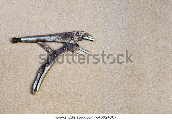 old rusty\
locking pliers on wooden\
background