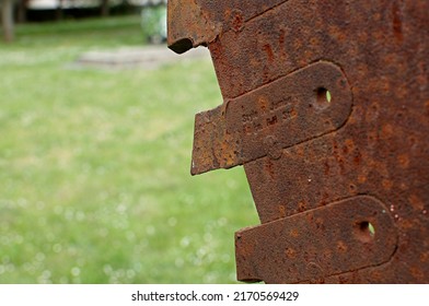 An old, rusty logging circular saw blade with focus on the saw tooth.