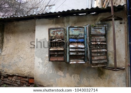 Old rusty mail boxes on the weathered wall. Obsolete broken mailboxes.