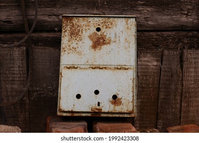 An Old Rusty Mailbox Sits In A Landfill