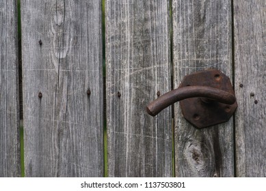 old rusty metal door handle on a wooden structural door