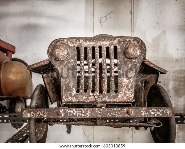 Old and rusty metal pedal car\
for kid, nostalgia for a time which has passed, vintage\
background