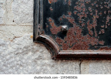 Old rusty metallic elements of the building decor like commemorative plaques with black and brown background attached to grey stone walls in Vieux Montreal.