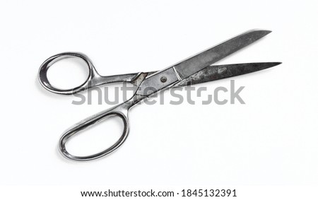 Old and rusty metallic scissors isolated on white background. Silver clippers