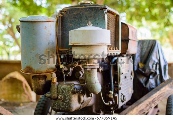 Old rusty motor engine of mobile electric generator\
on cart.