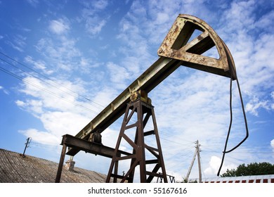 Old Rusty Oil Pump Jack Against The Sky