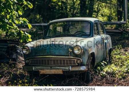 Old rusty overgrown abandoned soviet retro car