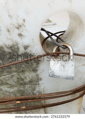 Old Rusty Padlock Wire Rope Locked White Concrete Urban Security Weathered Aged Outdoor

