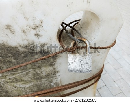 Old Rusty Padlock Wire Rope Locked White Concrete Urban Security Weathered Aged Outdoor
