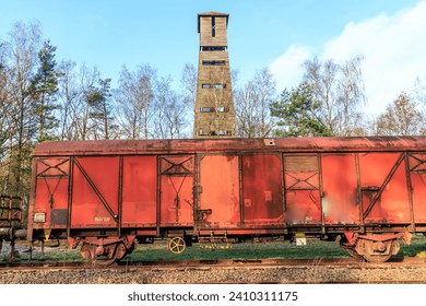 Old rusty red metal freight car on disused train tracks at old station, bare trees and observation tower of Hoge Kempen national park in background, sunny day in As, Limburg Belgium - Powered by Shutterstock