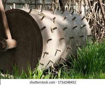 Old, Rusty Roller With Metal Spikes For Aeration Of Grass. Aeration Grass In The Garden