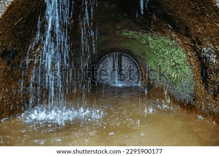 Old rusty round sewer drainage tunnel with leakage of water.