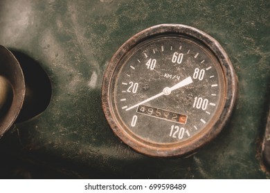 Old rusty round speedometer inside abandoned car.