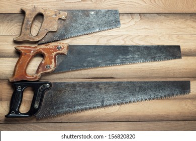 old rusty saws on the wooden background