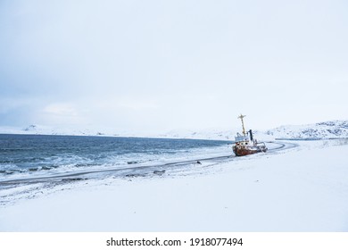 Old Rusty Ship On The Coast Of The Arctic Ocean In Winter.  