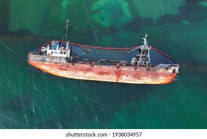 The old rusty ship was stranded by a storm. Oil spill from a tanker, environmental pollution. Top view of a rusty ship in the sea. - Shutterstock ID 1938034957