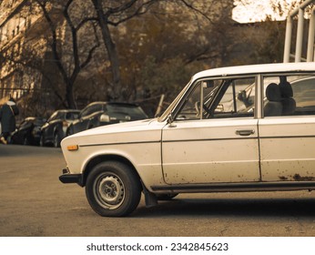 old rusty soviet white lada car in a yard of a residential building in Yerevan