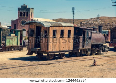 Old and rusty steam locomotive and wagon at an abandoned silver mine somewhere in Bolivia. The wooden wagon should be the last one robbed by Butch Cassidy and the Sundance Kid.