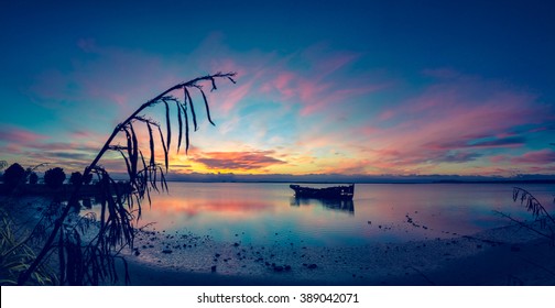 old rusty supply boat wreck near shore almost at beach during the sunrise in Motueka New Zealand blue tint