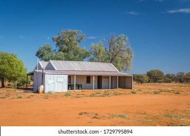 Old rusty tin shack by itself in the Australian Outback, surrounded by emptiness.