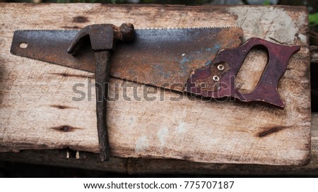 Old rusty tools hammer and hand saw for carpenter work