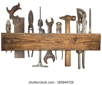 Old rusty tools under wooden plank.