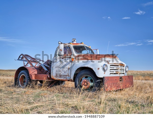 old rusty towing truck on a prairie, early\
spring scenery in Colorado